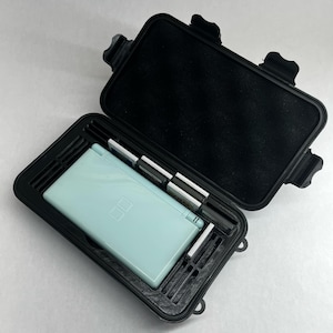 May include: A black hard case with a light blue Nintendo DS Lite handheld game console and multiple game cartridges inside.