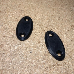 May include: Two black plastic oval-shaped wall mount brackets with three holes each.