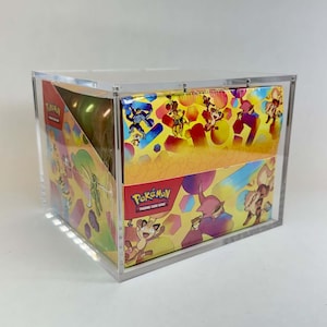 May include: A clear acrylic display case containing a sealed Pokemon Trading Card Game booster box. The box features a vibrant yellow and orange background with various illustrated Pokemon characters and the Pokemon Trading Card Game logo.