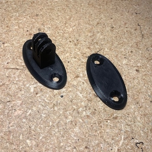 May include: Two black plastic camera mounts, one with a GoPro-style mount and the other with two holes.
