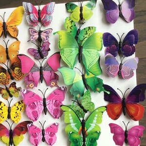May include: A collection of colorful butterfly wall decor. The butterflies are made of plastic and have a 3D effect. They are perfect for adding a touch of whimsy to any room.