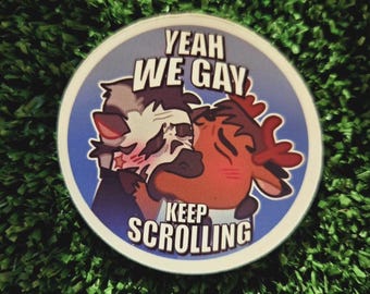 May include: A circular sticker with a blue border. The text "YEAH WE GAY KEEP SCROLLING" is displayed. Two cartoon animals are embracing. One is white and grey, the other is brown and red.