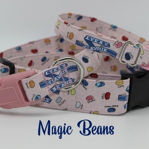 May include: Two pink and white dog collars with a blue ribbon design and the text "Every Flavour Bean". The collars have pink and black buckles. The collars are on a white background with the text "Magic Beans" in blue.