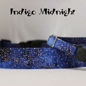 May include: A blue and gold patterned cat collar with a black breakaway buckle. The collar has the text "Indigo Midnight" printed on it.