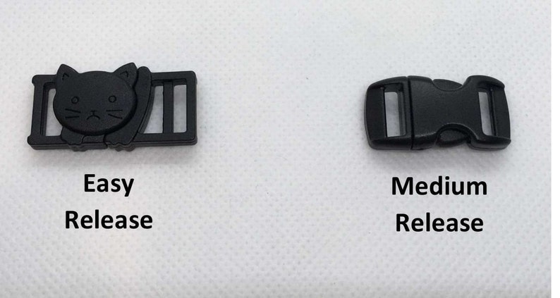 May include: Two black plastic buckles, one with a cat design and the text "Easy Release" and the other with the text "Medium Release".