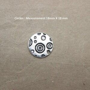 Puede incluir: Encanto de plata con un dise&ntilde;o circular que presenta c&iacute;rculos conc&eacute;ntricos y puntos. El encanto mide 18 mm de di&aacute;metro. C&iacute;rculos: Medida 18 mm X 18 mm