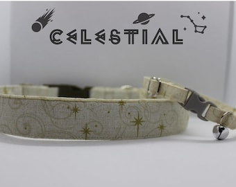 Puede incluir: Un juego de dos collares para gatos con una base de tela blanca y un patrón de estrellas doradas. Los collares tienen una campanilla plateada y una hebilla de plástico gris. El collar más grande tiene una hebilla marrón. Los collares están etiquetados con "CELESTIAL" con un cometa, un planeta y una constelación.