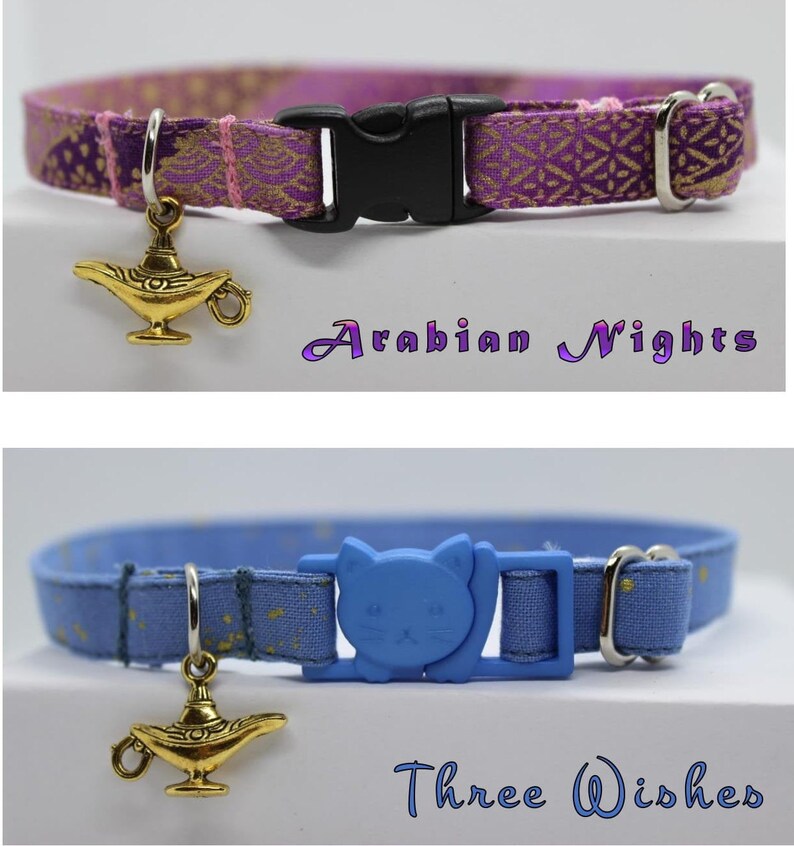K&ouml;nnte beinhalten: Zwei Katzenhalsb&auml;nder mit einem goldenen Dschinnenlampen-Anh&auml;nger. Das erste Halsband ist lila mit goldenen Akzenten und dem Text "Arabian Nights". Das zweite Halsband ist blau mit goldenen Sternen und dem Text "Three Wishes".