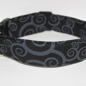 May include: Black dog collar with a gray swirl pattern.