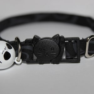 May include: Black cat collar with a black cat buckle and a white bell with a black Jack Skellington face.