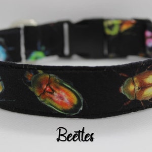 Puede incluir: Collar de perro negro con estampado de escarabajos coloridos. El collar tiene una hebilla negra y est&aacute; etiquetado como "Beetles".