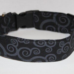May include: Black dog collar with a gray swirl pattern.