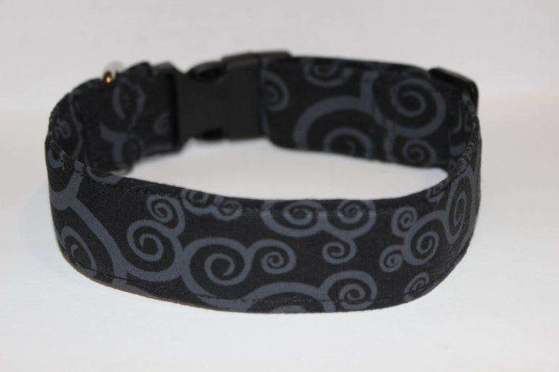 May include: Black dog collar with a gray swirl pattern.