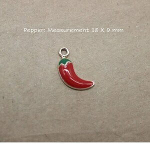 Puede incluir: Un amuleto de chile rojo y verde, que mide 18 x 9 mm.  Pimienta: Medida 18 x 9 mm