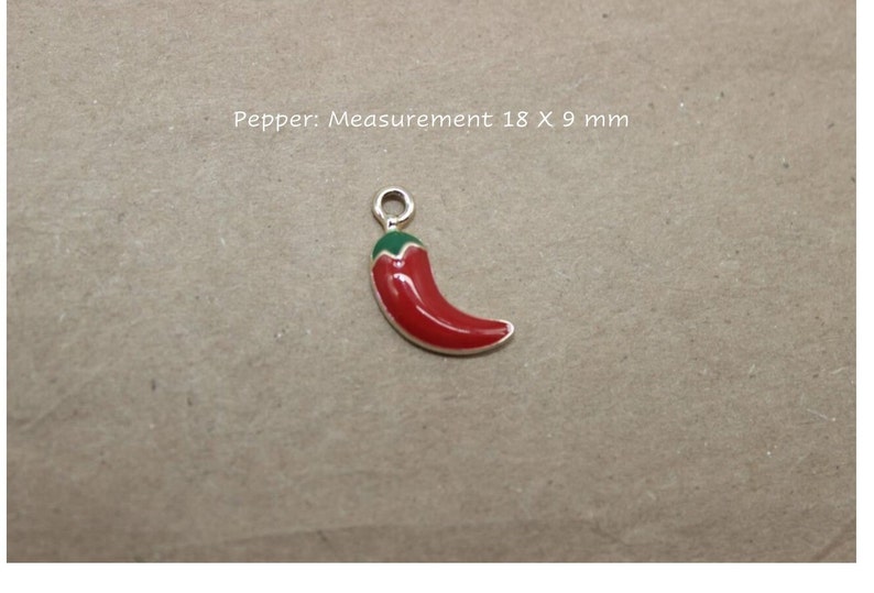 Puede incluir: Un amuleto de chile rojo y verde, que mide 18 x 9 mm.  Pimienta: Medida 18 x 9 mm