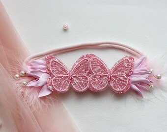Può includere: Fascia rosa con tre farfalle rosa scintillanti e dettagli floreali rosa.