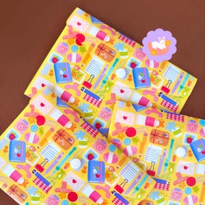 May include: Three yellow document folders featuring a repeating pattern of stationery items including blue notebooks, pink envelopes, pencils, paper clips, and small rabbit icons. Each folder has a white circular snap closure button.