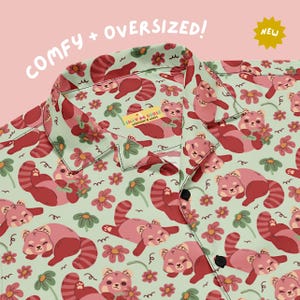 May include: A light green button-down shirt featuring a repeating pattern of red pandas and pink flowers. The shirt has a collar and black buttons. A label inside the collar reads SILLY GOOSE WORKSHOP & WARES. Text on the image reads COMFY + OVERSIZED! and NEW.