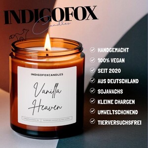 Puede incluir: Una vela encendida en un frasco de vidrio marr&oacute;n con el texto "Vanilla Heaven" en una etiqueta blanca. La vela es de INDIGOFOX Candles. El texto adicional incluye "Hecho a mano", "100% Vegano", "Desde 2020", "Hecho en Alemania" y "Cera de soja".