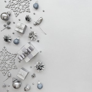 May include: Silver Christmas ornaments, gift boxes, and snowflakes on a white background.
