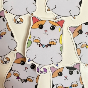Könnte beinhalten: Sechs bunte Katzenaufkleber mit verschiedenen Pride-Flaggen-Herzketten. Die Katzen sind weiß mit schwarzen Flecken und orange, gelben und violetten Akzenten. Die Aufkleber befinden sich auf weißem Hintergrund.