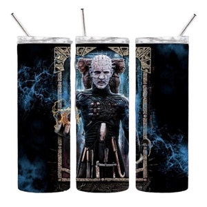 May include: A stainless steel tumbler featuring a horror-themed design. The artwork depicts a pale figure with pins in its head, set against a dark, stormy background. The tumbler includes a silver straw and a black lid.