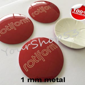 May include: Four red, round, 1 mm metal car emblems with the word "rotiform" in gold lettering. The emblems have a glossy finish and are backed with adhesive.