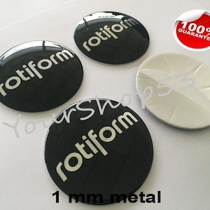 May include: Four black, round, 1 mm metal car emblems with the word "rotiform" in white lettering.
