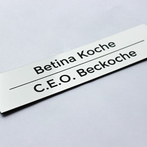 May include: A silver nameplate with black text that reads "Betina Koche C.E.O. Beckoche".