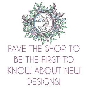 May include: A logo for a shop called "Papercut Studio" featuring a hand giving a thumbs up surrounded by a wreath of flowers and a butterfly. The text "Fave the shop to be the first to know about new designs!" is below the logo.