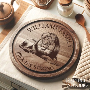 May include: A round wooden cutting board with a lion design and the text "Williams Family Proud & Strong".