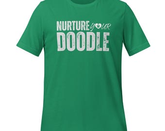 May include: A green t-shirt featuring the white text "NURTURE your DOODLE" and a paw print graphic. The shirt has a crew neck and short sleeves.
