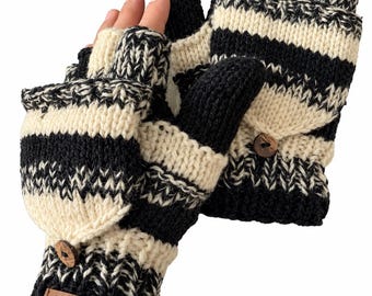 May include: A pair of black and cream striped convertible fingerless gloves with a fold-over mitten flap secured by a small brown wooden button. The wrist features a ribbed cuff with a rectangular brown leather tag embossed with the text ALMA.