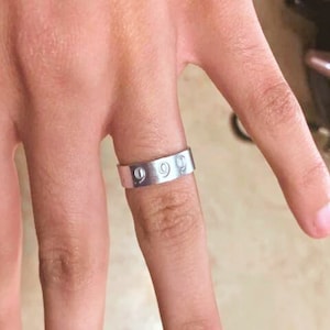 May include: A silver band ring with the number "999" engraved on it.