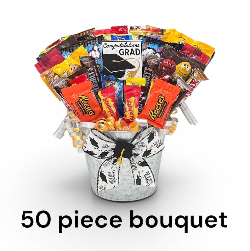 May include: A candy bouquet in a galvanized metal bucket, featuring a variety of wrapped candies and a graduation-themed card. The bucket is adorned with a graduation cap bow and ribbon. The text "50 piece bouquet" is at the bottom.