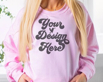Könnte beinhalten: Ein rosa Sweatshirt mit einer schwarzen Retro-Grafik, auf der "Your Design Here" mit einem Herz und einem Pfeil steht.