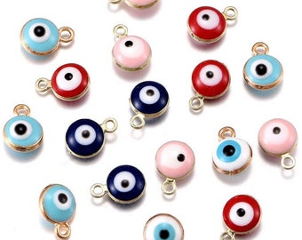 May include: A collection of small, round charms with an eye design. The charms feature a gold-colored metal border and come in various colors, including light blue, pink, red, and dark blue. Each charm has a small loop for attaching to jewelry.