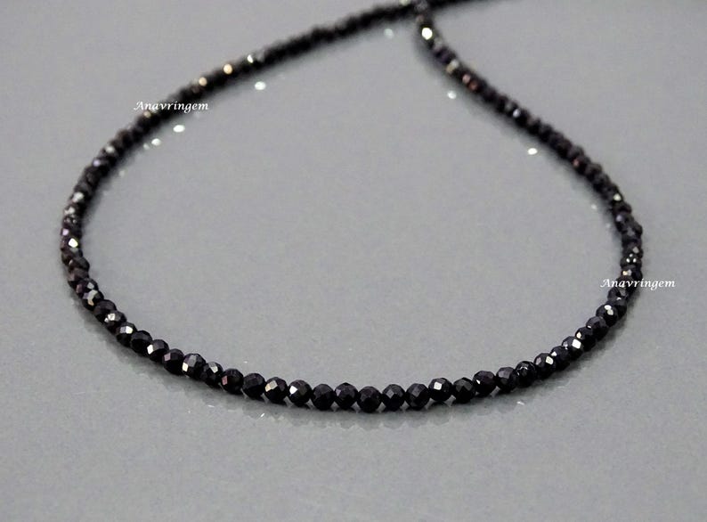May include: A black beaded necklace made of small, faceted gemstones. The necklace is approximately 18 inches long.