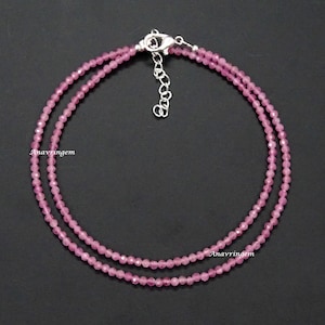Op de afbeelding: Een delicate ketting met twee rijen roze edelsteen kralen en een zilveren sluiting.