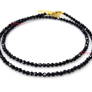 May include: A black spinel gemstone necklace with a gold clasp. The necklace is made of small, faceted beads and is approximately 18 inches long.