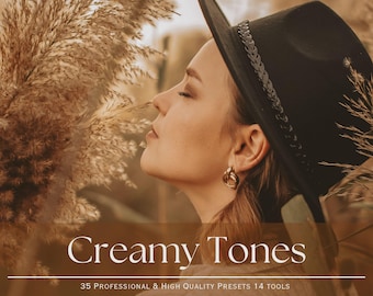 May include: A woman wearing a black fedora and gold hoop earrings is standing in a field of tall, dried grasses. The text "Creamy Tones" is superimposed on the image, along with the text "35 Professional & High Quality Presets 14 Tools Mobile & Desktop".