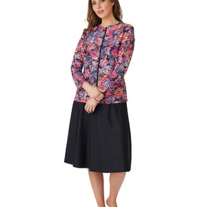 May include: A black and red long-sleeved shirt with a floral print and a black zipper. The shirt is paired with a black knee-length skirt.