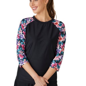 May include: Black long-sleeved shirt with a floral print on the sleeves. The shirt has a round neckline and a baseball-style design.