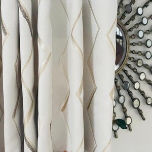 May include: White sheer curtains with a geometric pattern of gold lines forming diamond shapes.