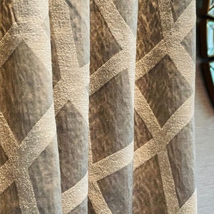 May include: Close-up of a gray curtain with a white geometric pattern. The pattern is made up of overlapping diamonds and lines.