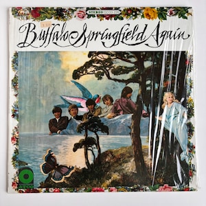以下が含まれることがあります： Buffalo Springfield Againのレコードジャケット。4人のバンドメンバー、青いドレスを着た女性、大きな蝶、青い鳥のシュールなコラージュが描かれています。縁は色とりどりの花とATCOのロゴで装飾されています。