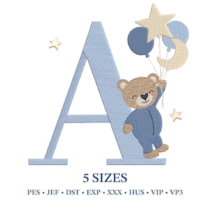 Può includere: Design ricamato con la lettera "A" azzurra e un orsacchiotto in tutina blu che tiene in mano palloncini a forma di stella, luna e due palloncini rotondi. Stelle dorate sono sparse intorno alla lettera. Il testo "5 SIZES" è sotto.