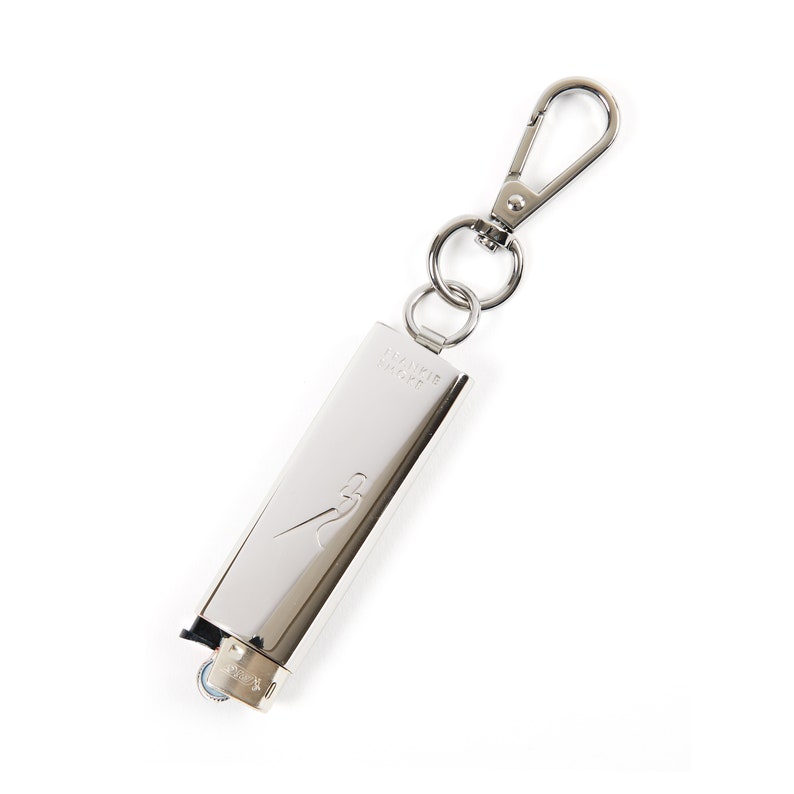 May include: A silver lighter with a keychain attached. The lighter has the words "AWAKE" and "CRAFT" engraved on it.