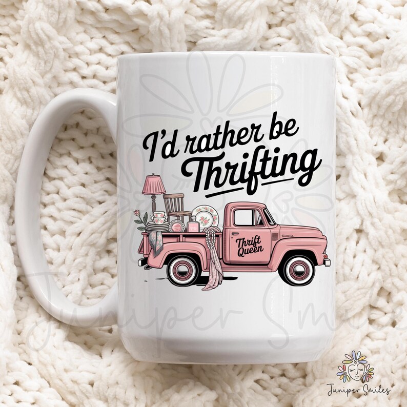 May include: White ceramic mug with a large handle. The mug features a pink vintage truck graphic filled with thrifted items, and the text "I'd rather be Thrifting". The mug also has the text "Thrift Queen".