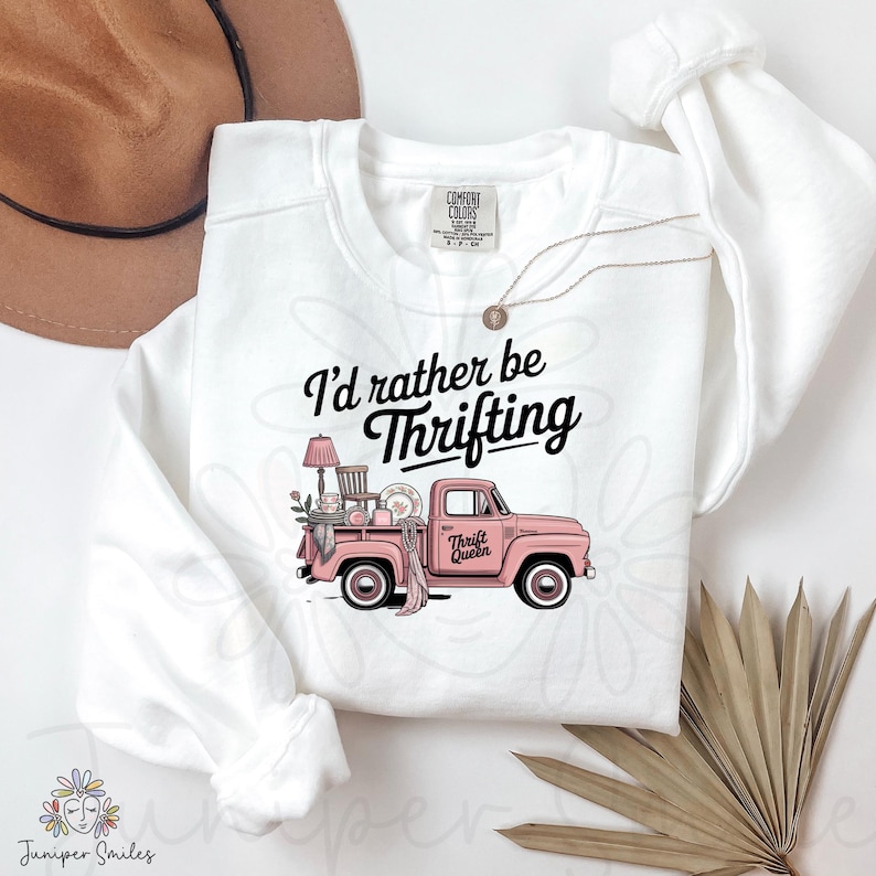 May include: White crew neck sweatshirt featuring the text "I'd rather be thrifting" and a pink vintage truck graphic. The truck is loaded with thrifted items. The words "Thrift Queen" are on the truck door.